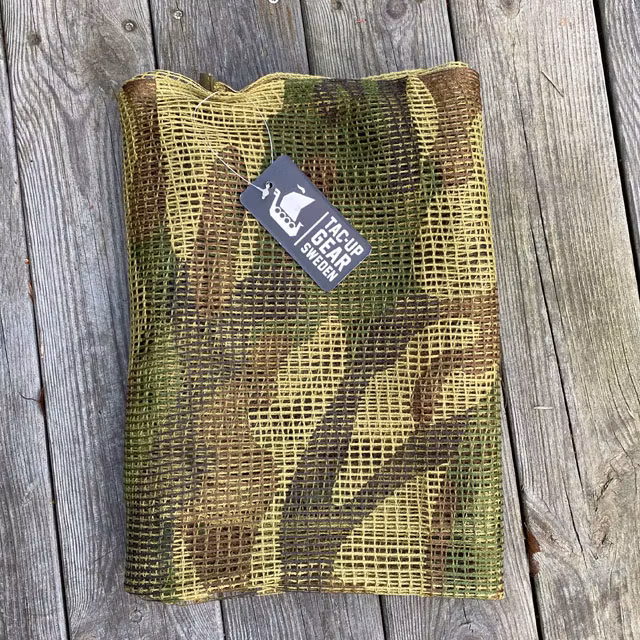 Scrim Net Scarf Woodland laying flat and folded on a wooden floor
