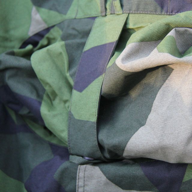 Hood secured by a strap with snapbutton on a Tarp Poncho M90.