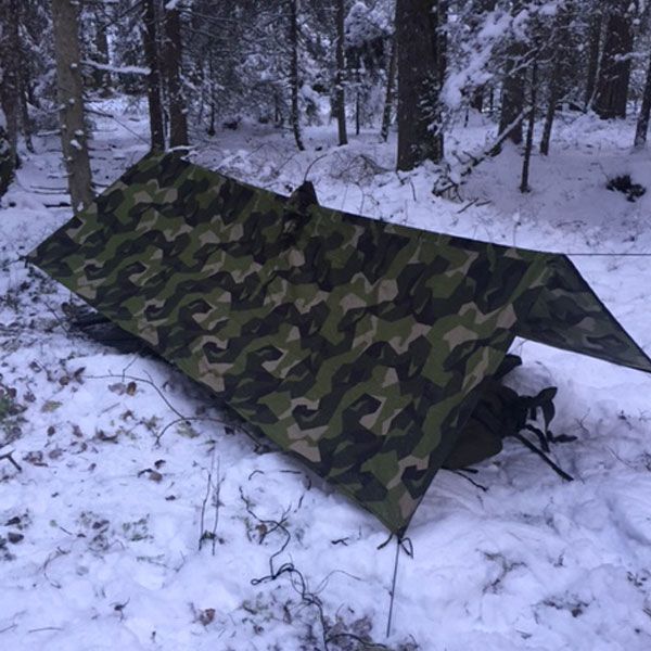 Shelter set up using a Tarp Poncho M90 in Swedish winter scenery.