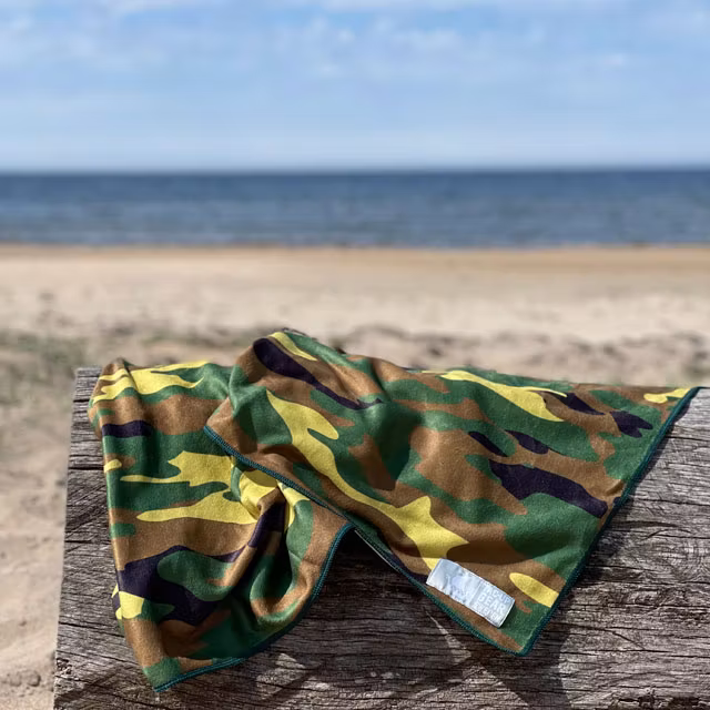 A Towel Camouflage from TAC-UP GEAR on a log at the beach in the sun