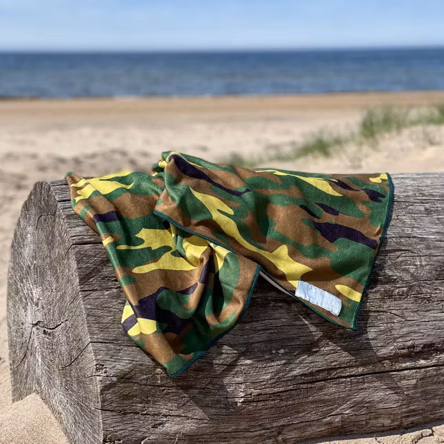 A Towel Camouflage from TAC-UP GEAR on a log at the beach