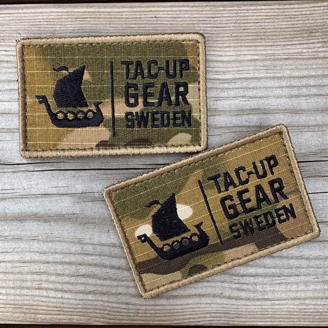 Two TUG Multicam Hook Patches displayed on a wooden surface