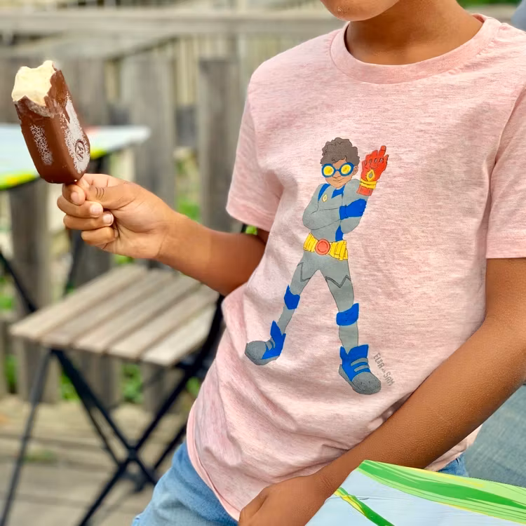 Rosa T-shirt ekologisk bomull för barn, med en superhjälte på med mörk hy.