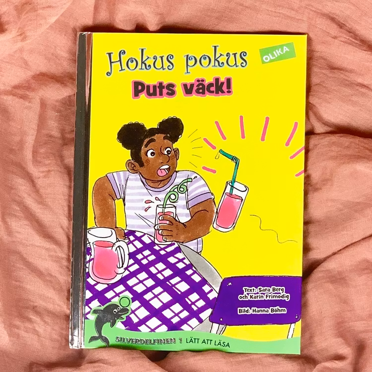 lätt att läsa bok, Hokus pokus: Puts väck! Författare Karin Frimodig & Sara Berg, Illustratör Hanna Böhm från Olika förlag. Mångfald bland karaktärerna där barn med mörk hy är representerade.
