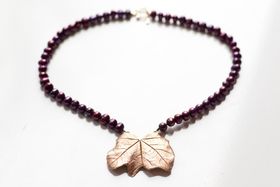 Bronslöv på lila pärlhalsband