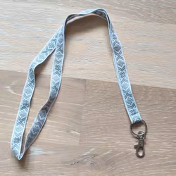 Nyckelband med dräktband ljusgrå på vit med