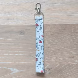Kort nyckelband blomranka på vit med karbinhake