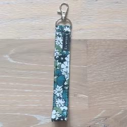 Kort nyckelband grön, vit och svart blommigt med karbinhake