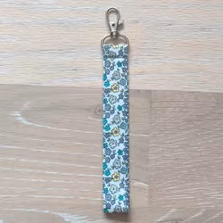 Kort nyckelband blommor på vitt med karbinhake