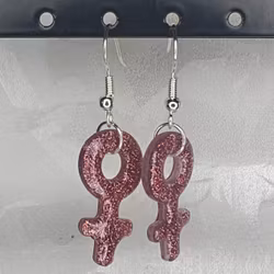 Örhängen med små kvinnosymboler med glitter mörkrosa