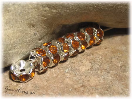 Silvrig rondell med mörk bärn strass ca 7 mm