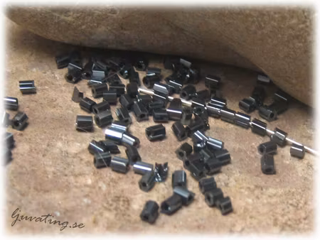 Mörkblå små stavar med AB lyster ca 2,5 x 2 mm