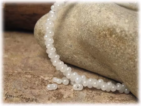 Vit farfalle pärla med pärlemorlyster ca 4x2 mm