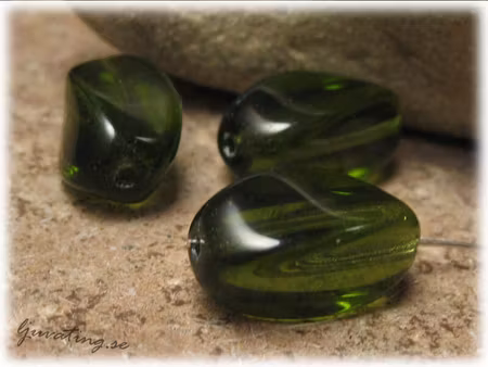 Grön lite vriden glaspärla ca 16x9 mm