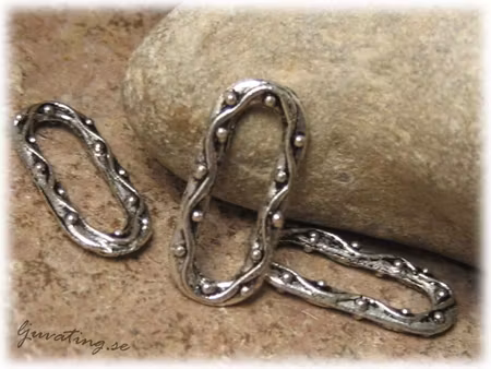 Avlång connector i metall med mönster ca 21x9 mm