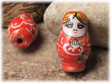 Pärla i porslin rödton rysk docka ca 27x16 mm