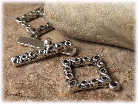 Toggle lås med mönster i metall  ca 24x20 mm