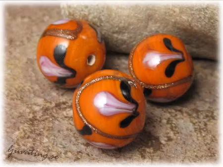 Glaspärla rund opak orange med blommor ca 15 mm
