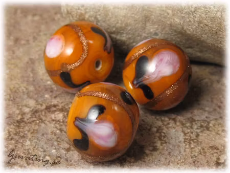 Glaspärla rund opak gulorange med blommor ca 15 mm