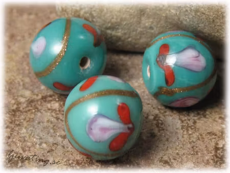 Glaspärla rund opak blågrön med blommor ca 15 mm