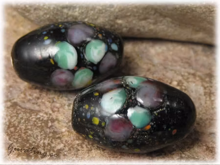 Svart opak oval pärla m blommor ca 23x14mm