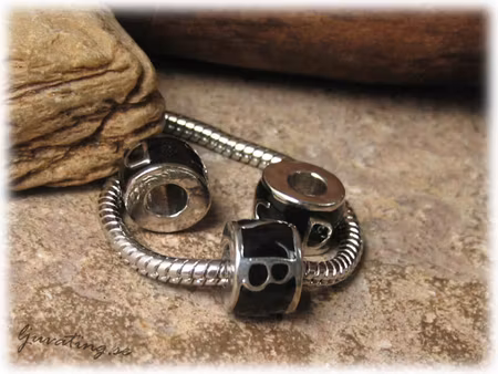 Ormlänkspärla svart med bokstäver ca 11x8 mm