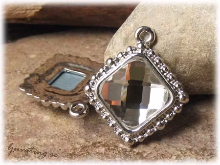 Hänge i metall  med clear fasett ca 32x28 mm