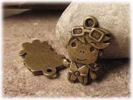 Berlock bronsfärgad pojke med pilotglasögon ca 23x15 mm