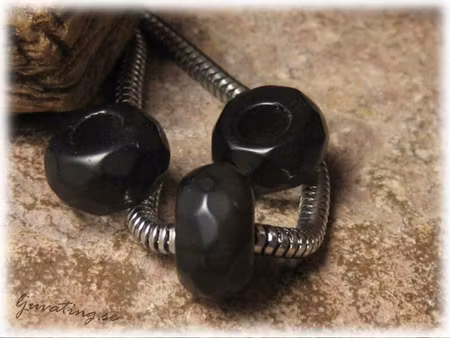 Ormlänkspärla facetterad svart cat eye ca 13x7 mm