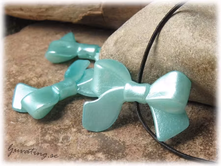 Rosett turkos i syntetmaterial ca 33x23 mm