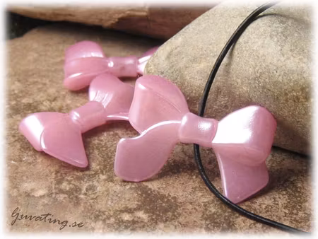 Rosett rosa i syntetmaterial ca 33x23 mm