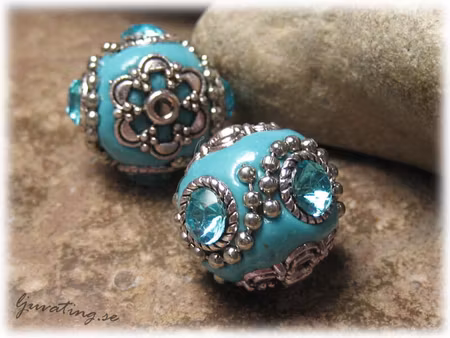 Turkos pärla med metalldetaljer och turkos strass