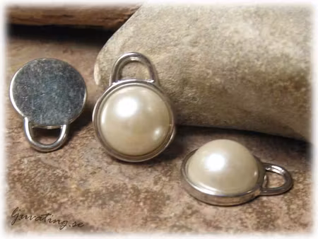 Berlock med pärla i syntet ca 21x17 mm