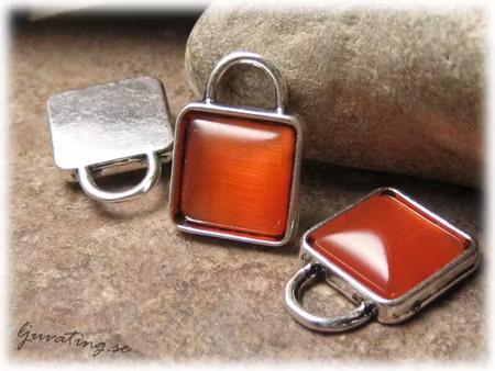 Berlock med orange cats eye pärla ca 21x15 mm