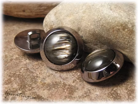 Knapp i syntet svartbrun med ram ca 22 mm