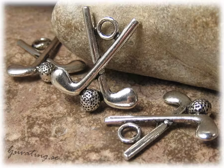 Berlock dubbel golfklubba i metall ca 25x22 mm