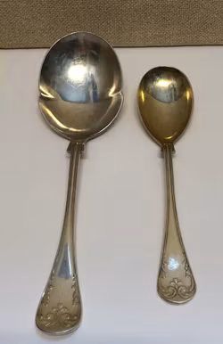 UPPLÄGGNINGSSKEDAR 2 st. nysilver,"Franska Liljan", 1900-tal.