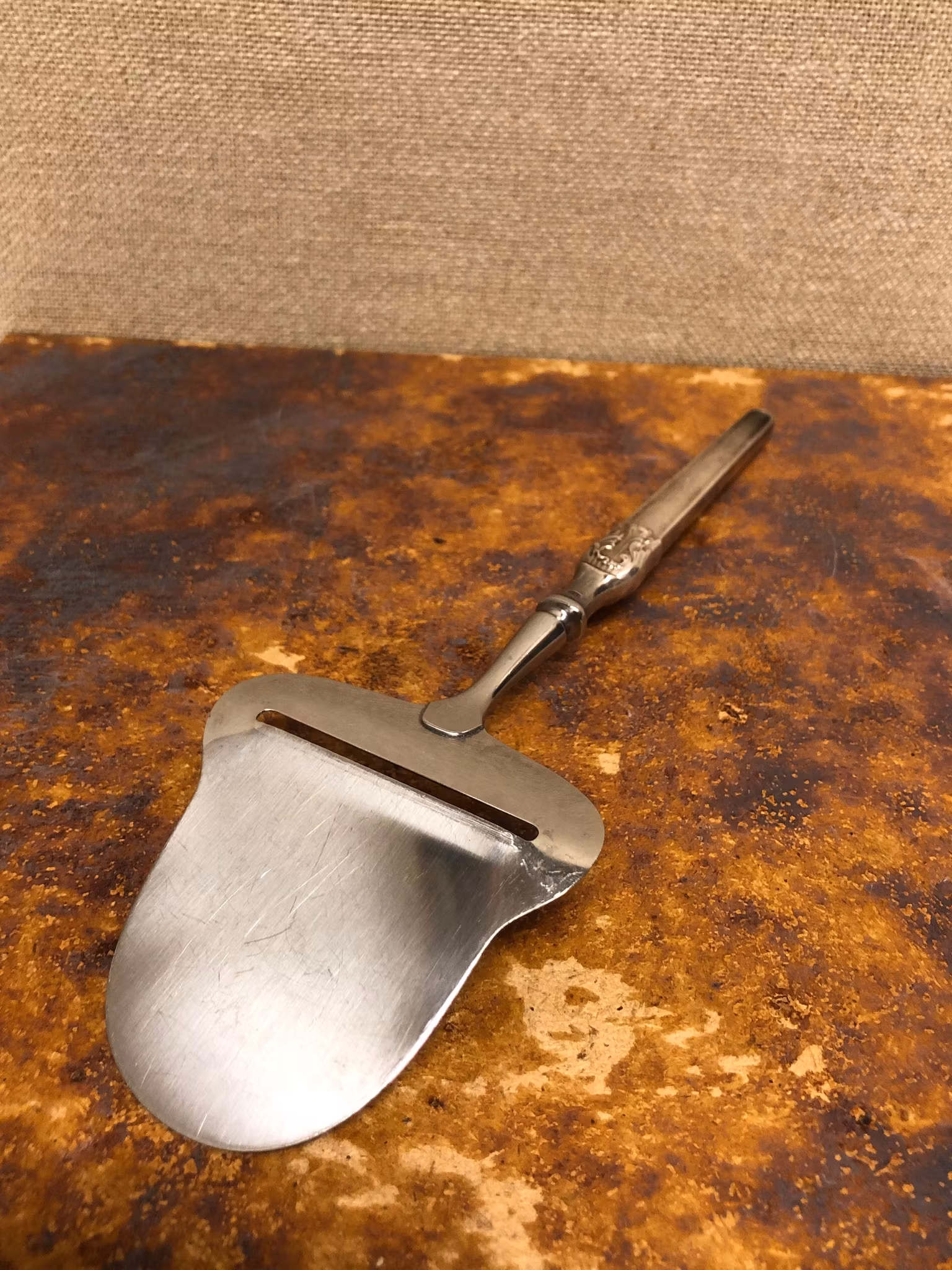 OSTHYVEL, nysilver/rostfritt, 1900-talets första hälft.