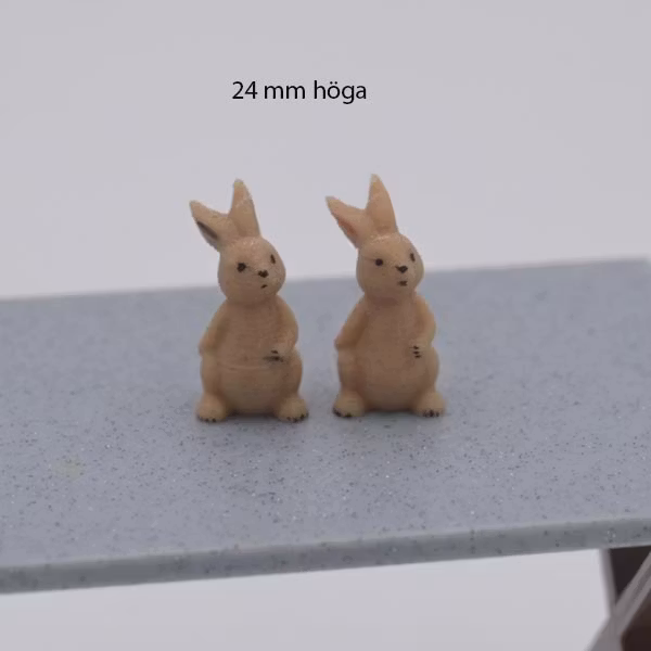 Kanin som sitter och har hand på magen 24 mm hög