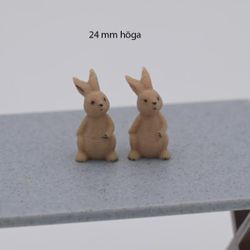 Kanin som sitter och har hand på magen 24 mm hög
