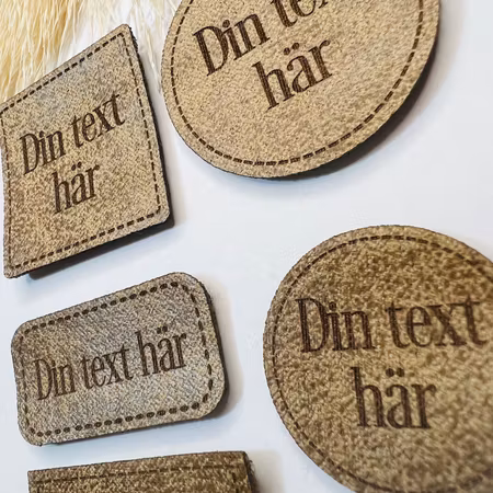 Konstläderlappar, ljusbrun, med streckad kant - egen text