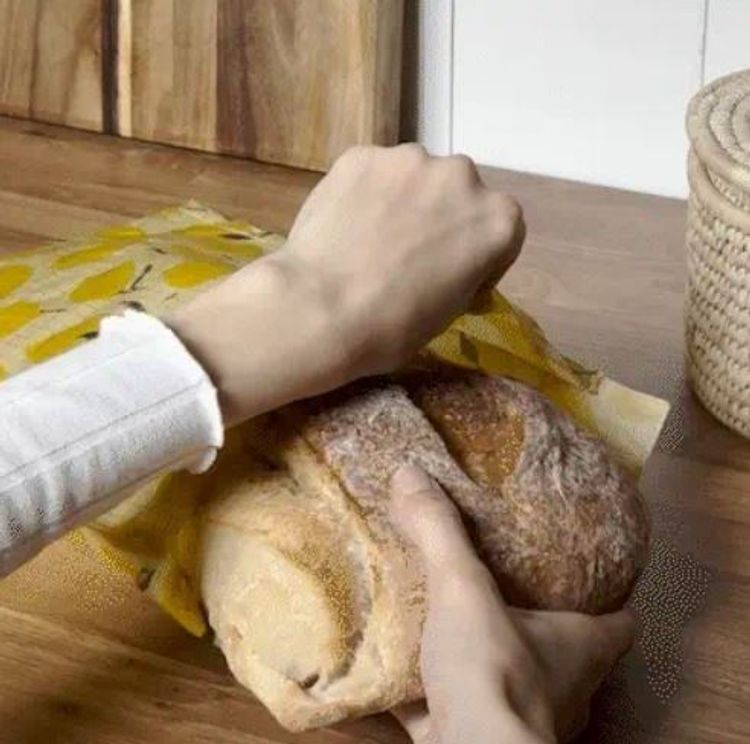 bivaxpåse där någon stoppar in ett stort bröd