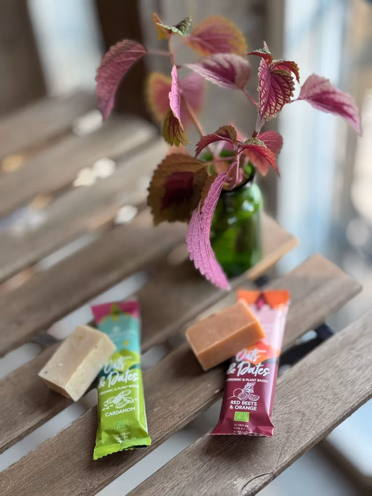 Vegansk energibar och tvål på ett bord med en stickling i vas