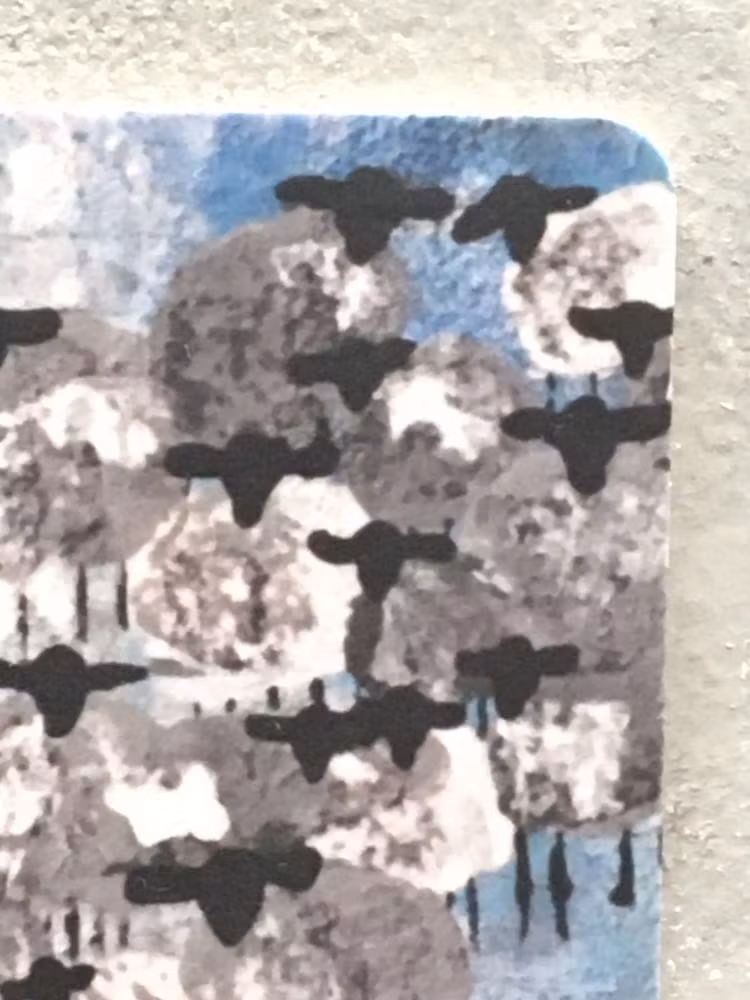 Fårmotiv i blått och grått. Får och lamm omvartannat på tåligt glasunderlägg. Inredningsdetalj i 9 x 9 cm.