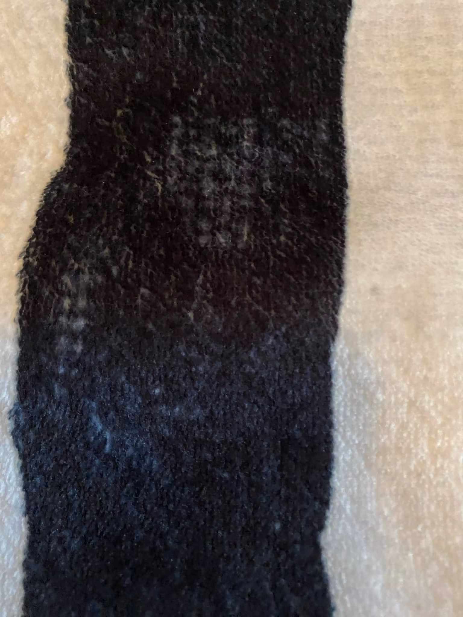 Oerhört skön fleece-filt i grått, svart och vitt som är extra lång för att kunna användas även av lite längre personer.