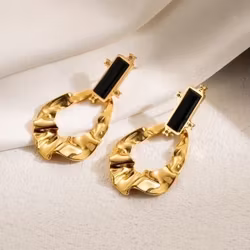 Statementörhängen i guld med svart detalj