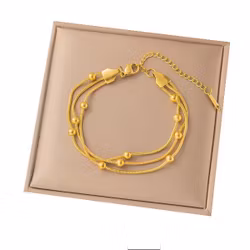 Treradigt armband med guldfärgade kulor
