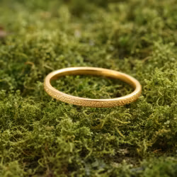 Smal guldring med sandblästrad yta