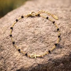 Guldfärgat armband med svart detalj och ankh