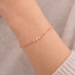 Guldfärgat armband med rosa detalj och ankh